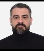 Headshot of mohamed Sahloul wearing a black poloneck against a white background