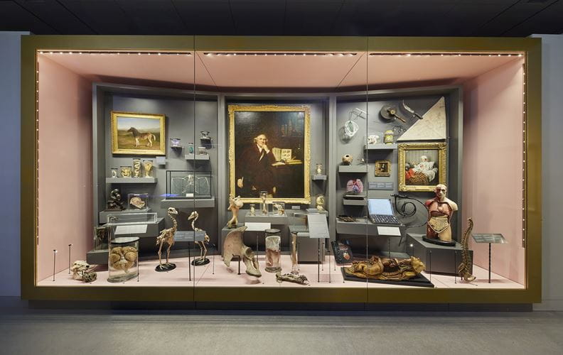 A display with a portrait of hunter at the centre, surrounded by old and modern anatomical specimens, instruments and art works. 