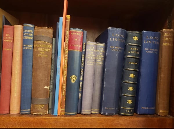 A shelf of bound volumes in various styles, all about Lord Lister or his works.