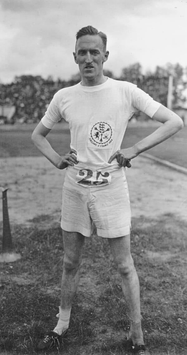 Stallard in white t-shirt and shorts, with race number 25.