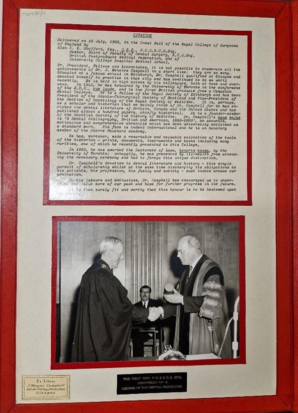 A photograph of two men in robes, shaking hands.